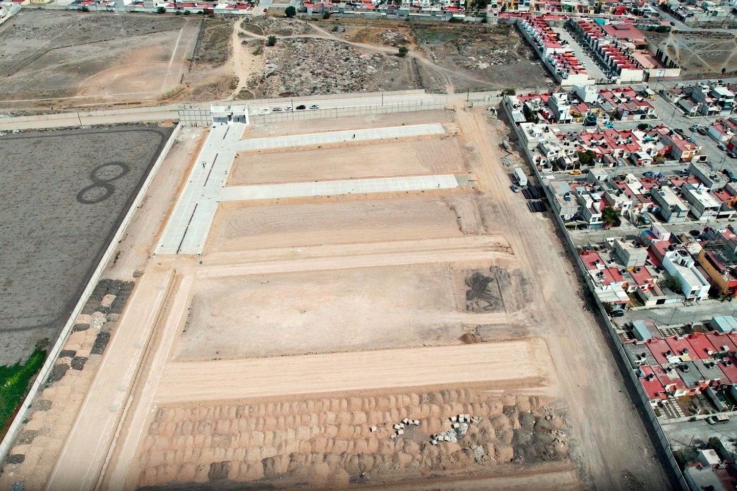 Vista aérea del terreno con la traza de las calles junto a una colonia