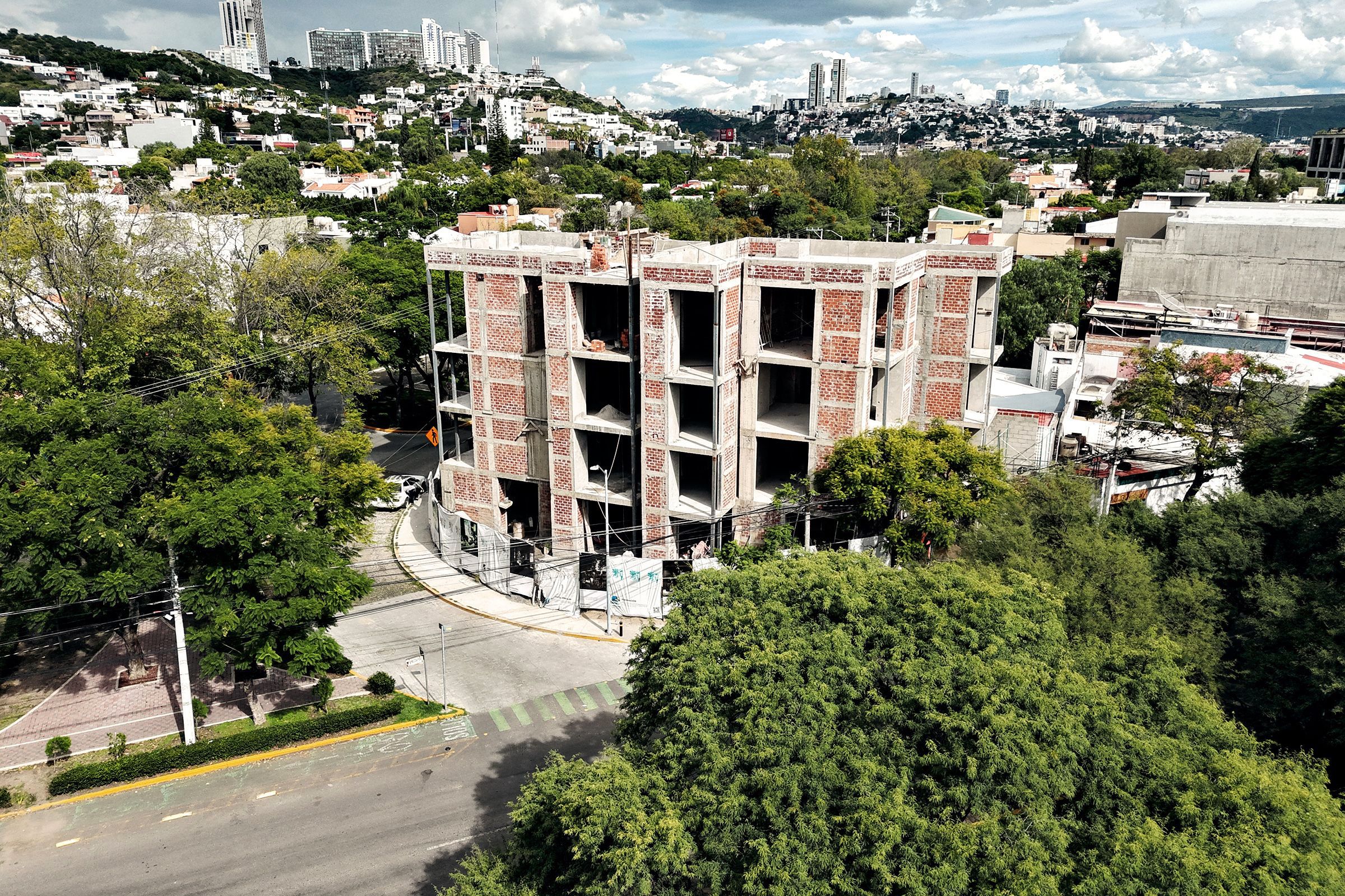 El edificio en obra negra visto desde Av. del Roble, con la ciudad al fondo