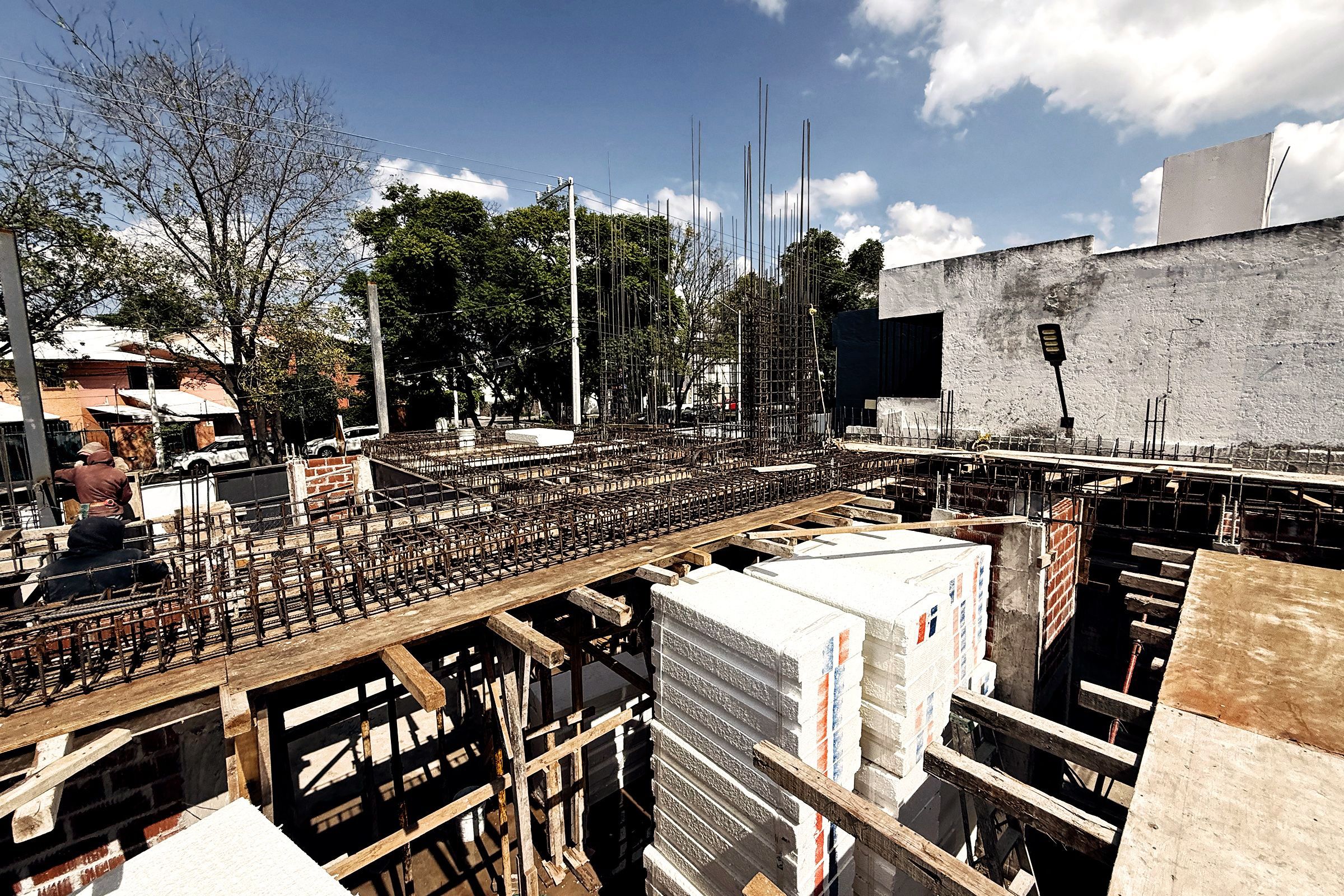 Armado de losa con bloques de casetón y la calle arbolada al fondo