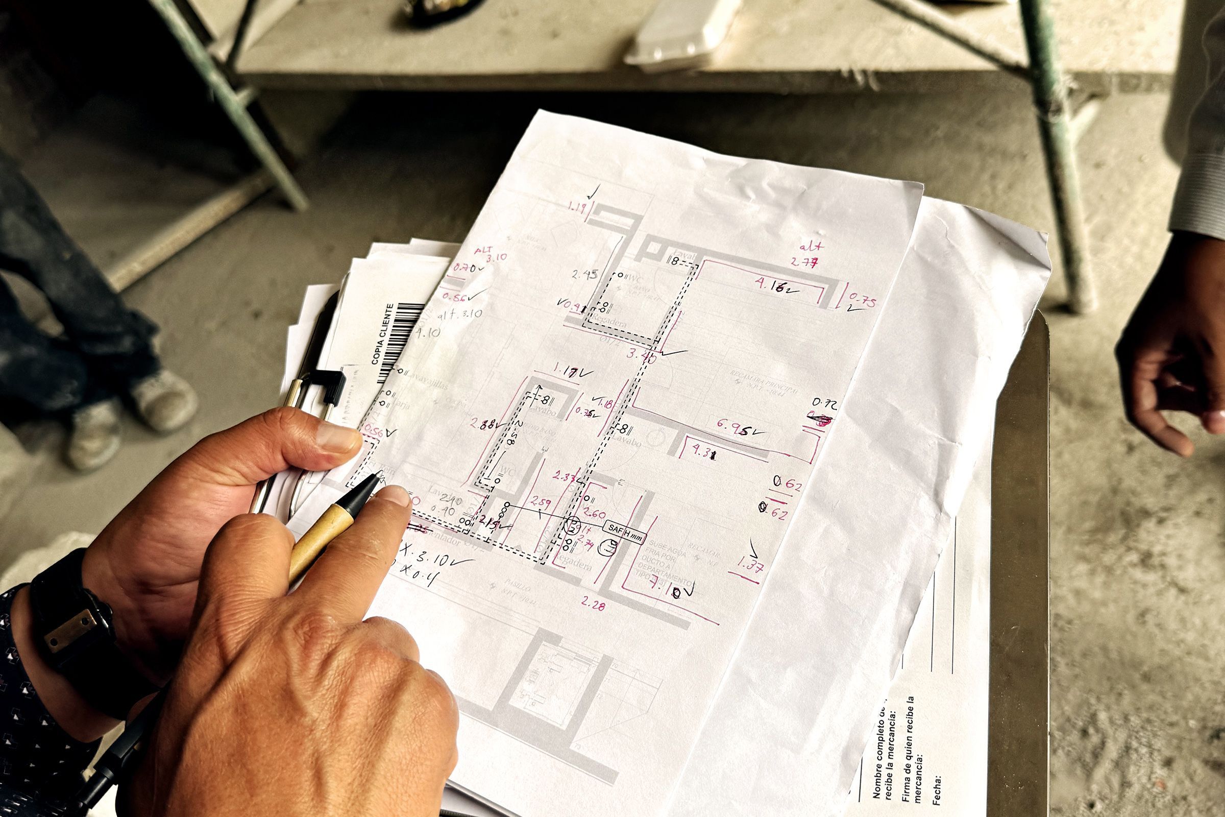 Manos revisando un plano impreso en la obra