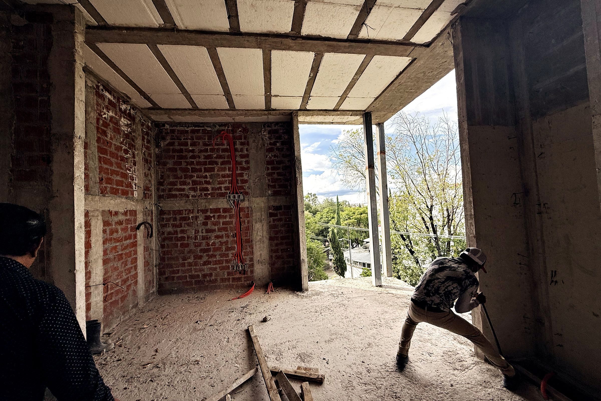 Recámara en obra negra con ventanal a los árboles