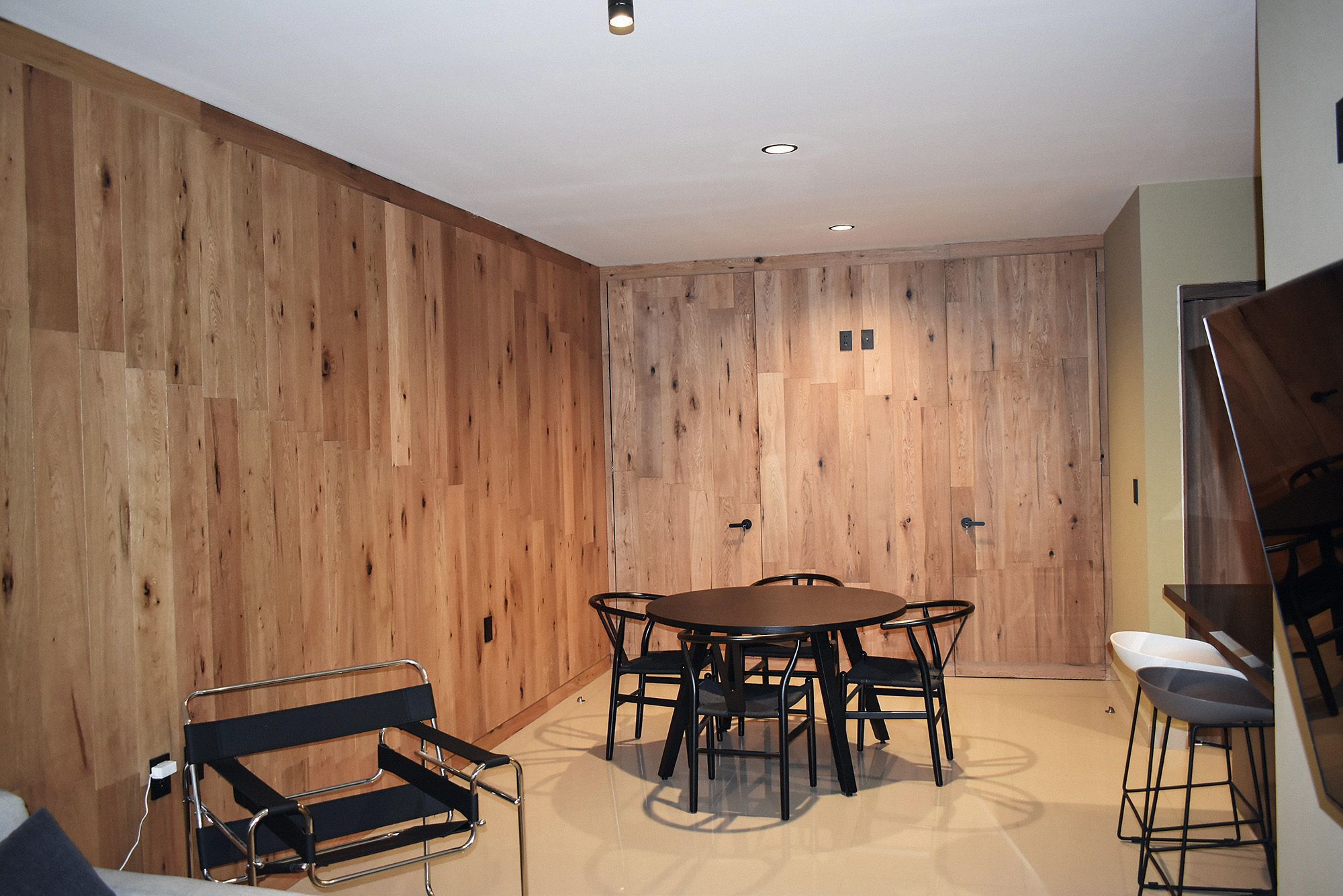 Comedor de un departamento Bach con muro de madera